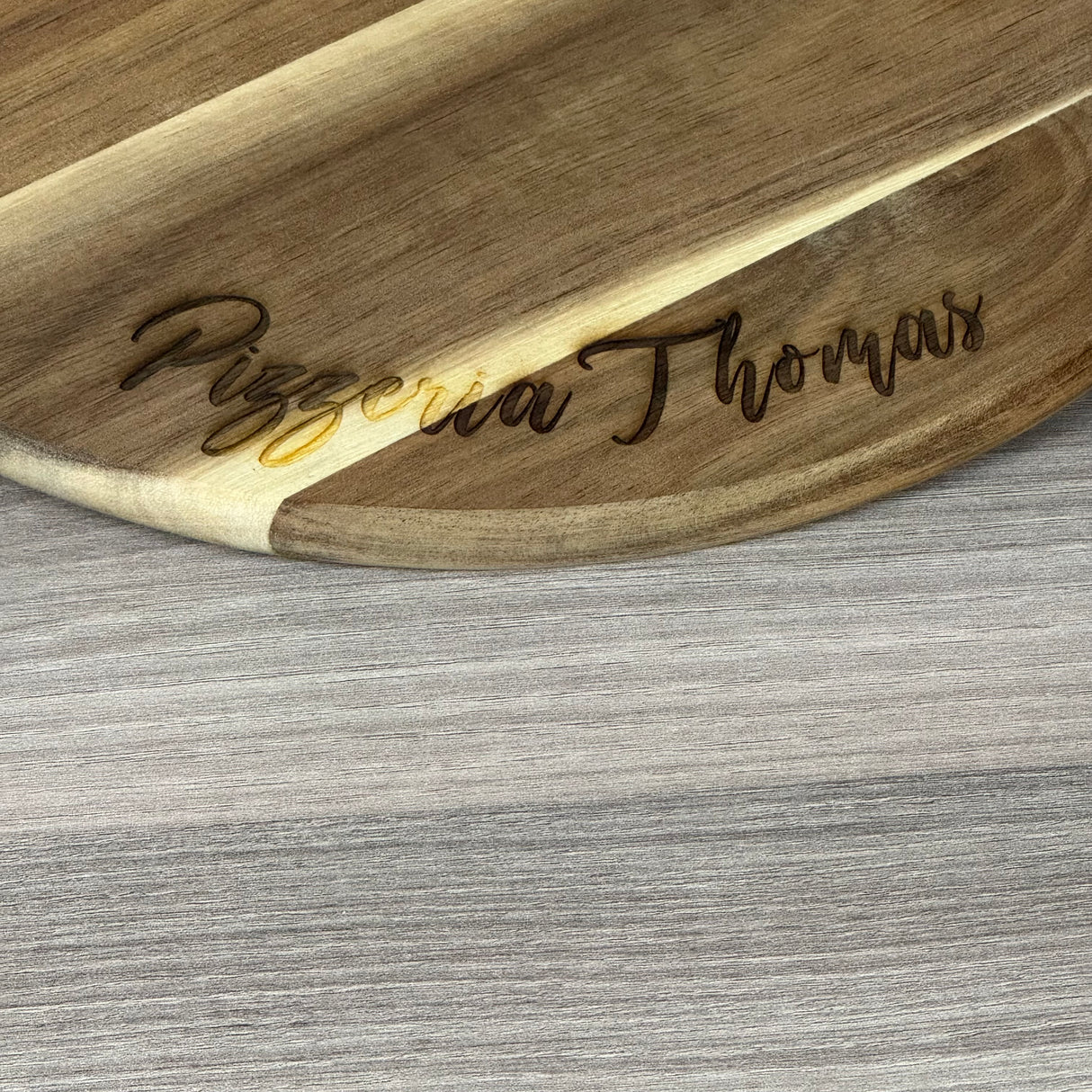 Dieses personalisierte runde Servierbrett aus FSC-zertifiziertem Akazienholz ist ein perfektes Geschenk für Familie oder Freunde. Mit individueller Gravur wie „Finger weg von [Name]’s Pizza“ wird es zu einem einzigartigen Küchenhighlight. Ideal zum Servieren von Pizza, Tapas oder Käseplatten bei gemütlichen Abenden. Das langlebige, antibakterielle Holz und der praktische Griff sorgen für Funktionalität und Stil. Ein dekoratives und praktisches Präsent für jeden Anlass.
