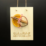 Weihnachtskarte „Weihnachtsduft liegt in der Luft“ aus 4 mm Pappelholz, liebevoll dekoriert mit getrockneter Orange, Apfel und Zimt.  
Mit Band zum Aufhängen, Größe ca. 16 × 11 cm – perfekte Deko für Advent und Weihnachten.  
Charmantes Mitbringsel oder festliche Geschenkidee, inklusive Geschenkverpackung mit Aufdruck „Ein zauberhaftes Weihnachtsfest“.  
Verbreitet Weihnachtsstimmung und erinnert an gemütliche Wintermomente.  
Personalisierbar für individuelle Botschaften – ein stilvolles Weihnachtsgeschenk